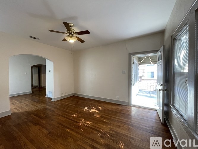 A room with wooden floors and a ceiling fan.