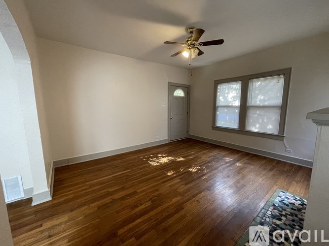 A room with a ceiling fan and wooden flooring.