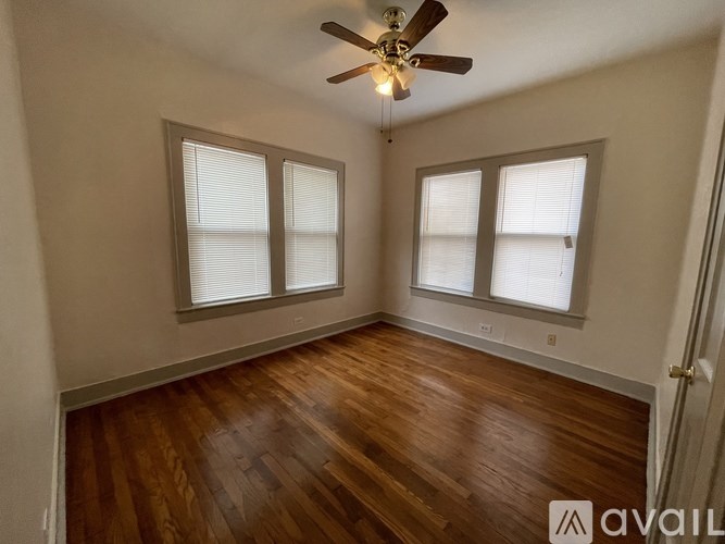 A room with wooden floors and a ceiling fan.