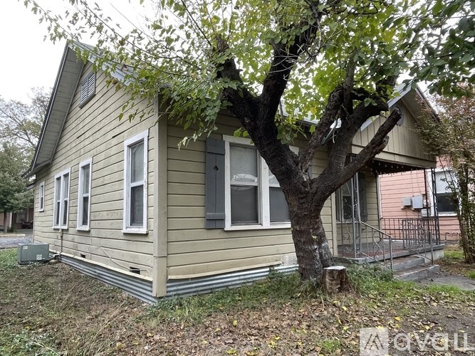 A small house with a tree in front of it.