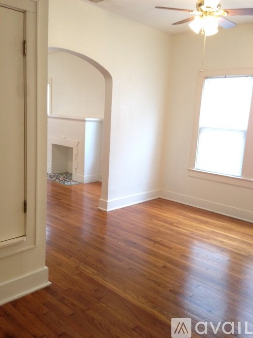 A room with wooden floors and a ceiling fan.