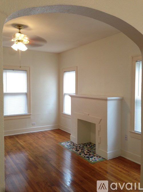 A room with a fireplace and a rug on the floor.