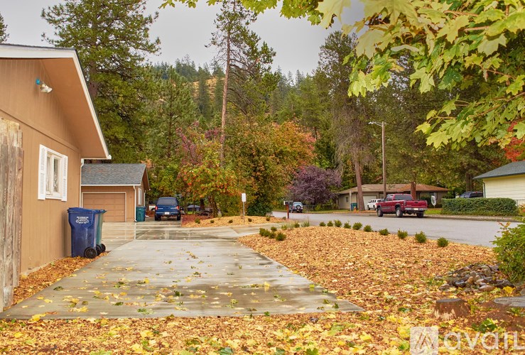 A residential street with houses and cars parked on the side.