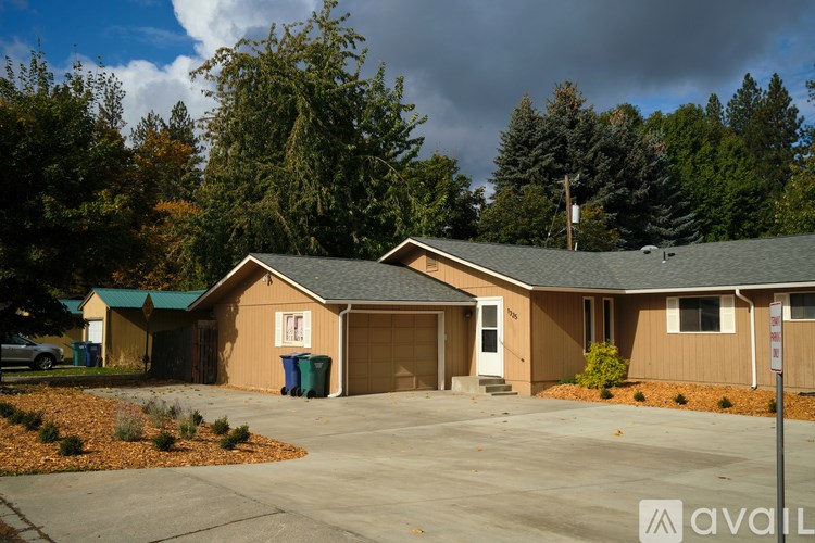 A house with a brown roof and a driveway in front of it.