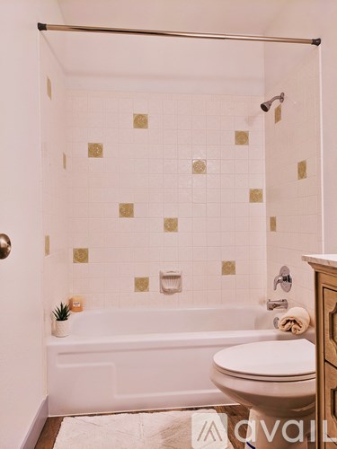 A white bathroom with a toilet, a tub, and a shower.