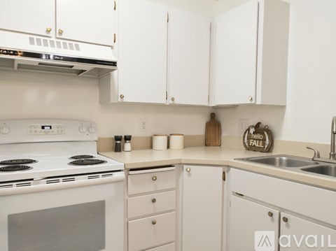 A kitchen with white cabinets and a stove top oven.