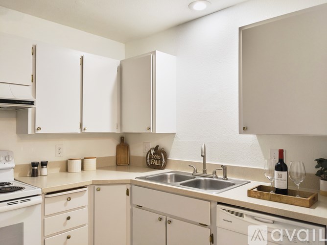 A kitchen with white cabinets and appliances.