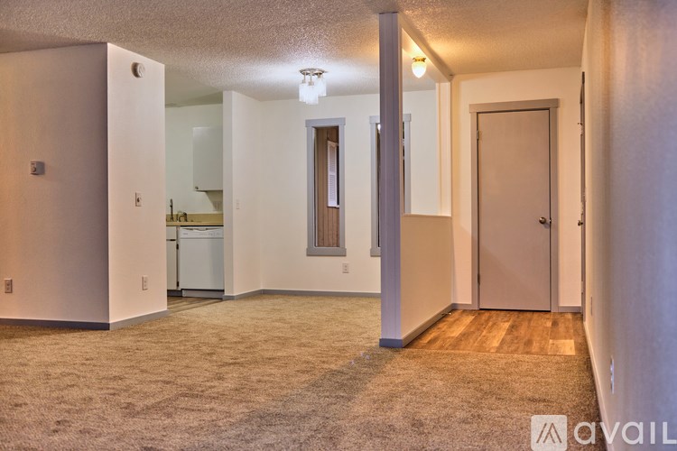 A carpeted room with a door and a window.