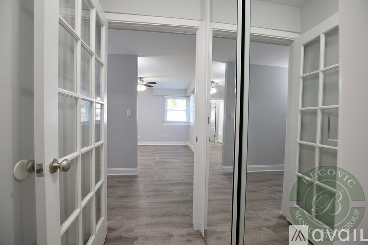 A room with a white door and a fan on the ceiling.