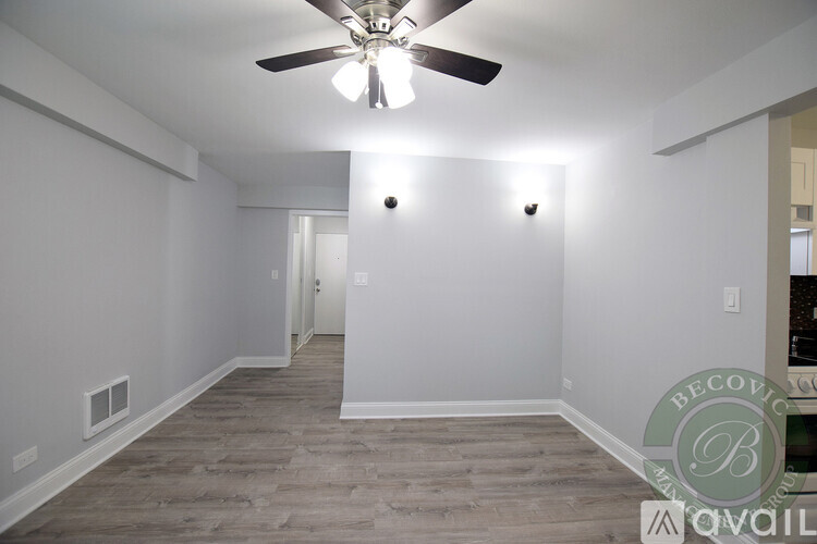 A spacious room with a ceiling fan and light fixture.