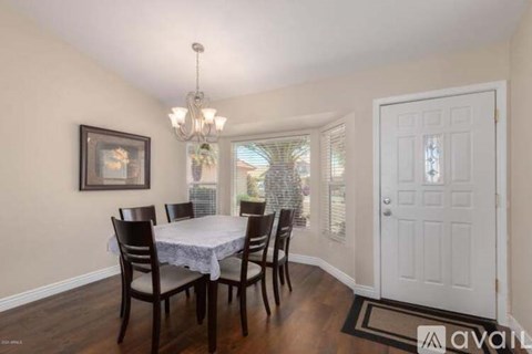 A dining room with a table set for four.