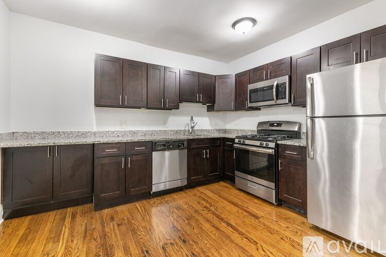 A kitchen with wooden floors and stainless steel appliances.