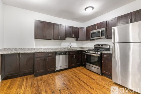 A kitchen with wooden floors and stainless steel appliances.