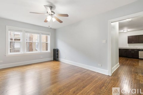A room with a ceiling fan and wooden floors.