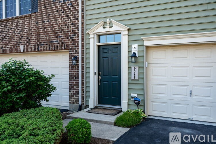A house with a dark blue front door and a white garage door.