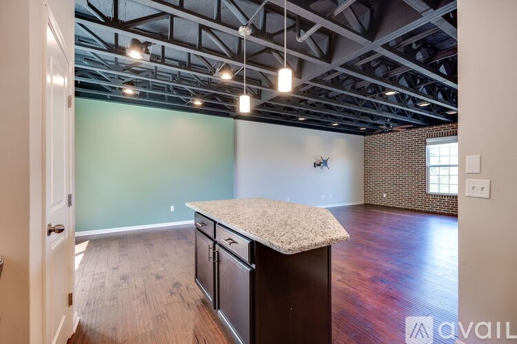 A kitchen with a granite countertop and wooden floors.