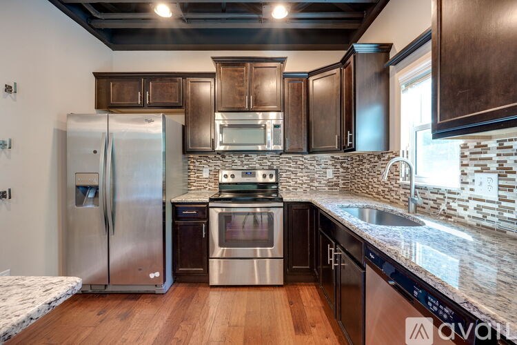 A kitchen with a stainless steel refrigerator, oven, and microwave.