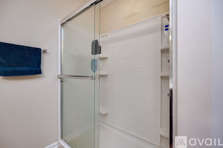 A white bathroom with a glass shower door.
