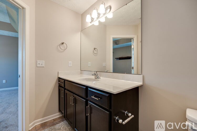 A bathroom with a sink, mirror, and cabinets.