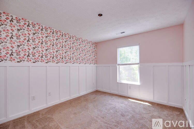 A room with a floral wallpaper and a window with blinds.