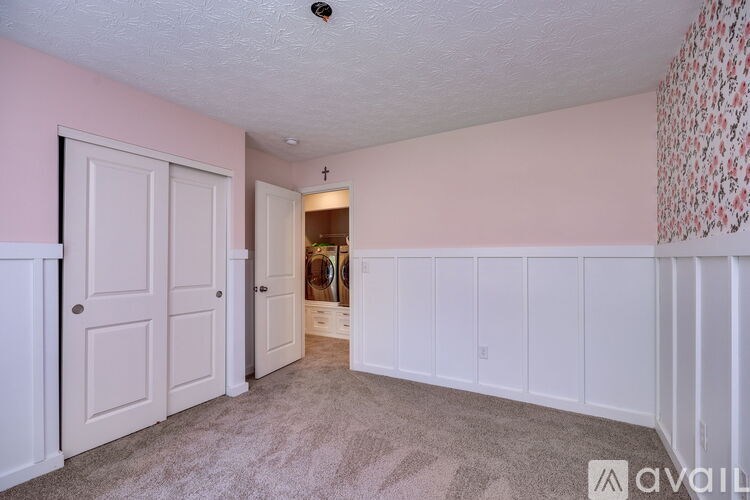 A room with a carpeted floor and a door on the left.