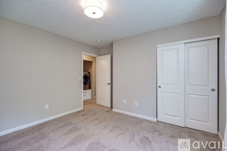 A room with a carpeted floor and two white doors.