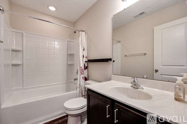 A white bathroom with a toilet, sink, and bathtub.
