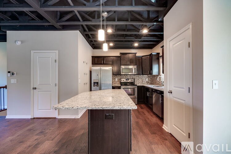 A kitchen with a granite countertop and wooden cabinets.