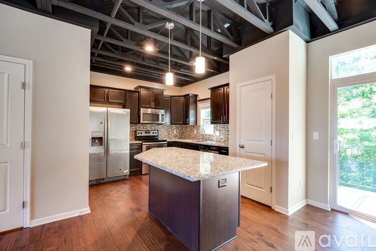 A kitchen with a granite countertop and stainless steel appliances.