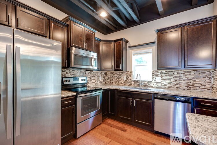 A kitchen with dark wood cabinets and stainless steel appliances.