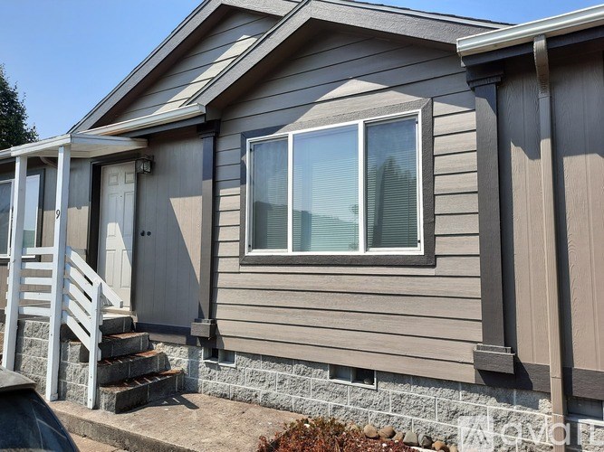 A house with a grey siding and a white door.