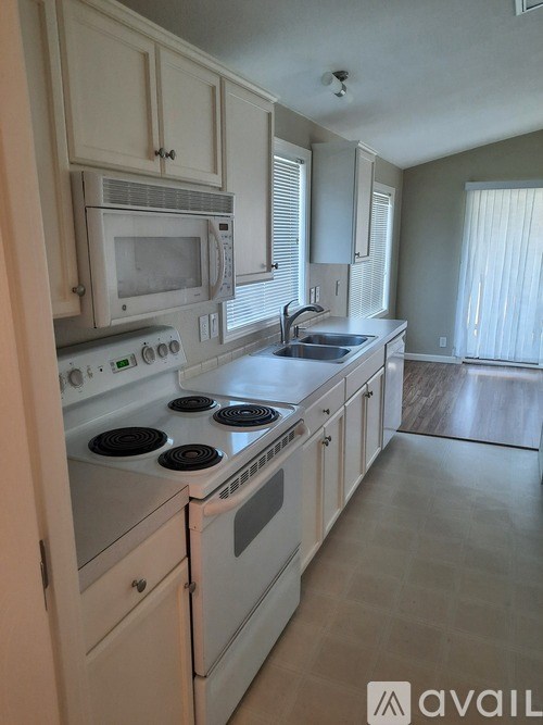 A kitchen with white appliances and cabinets.