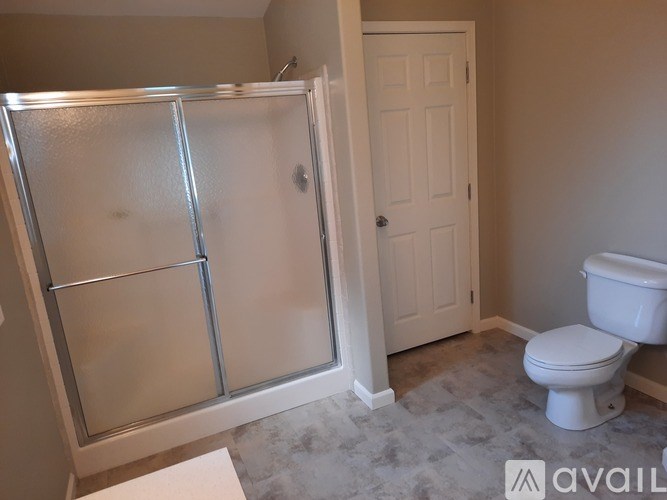 A bathroom with a toilet, sink, and shower.