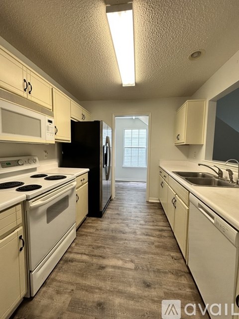 A kitchen with white appliances and cabinets.