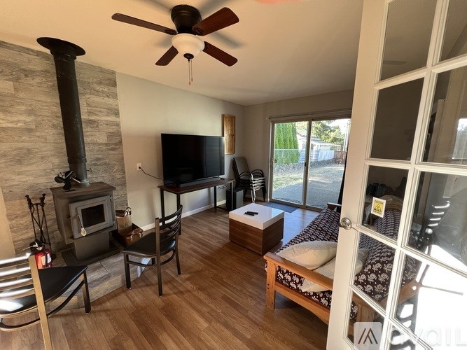 A living room with a wood stove and a television.
