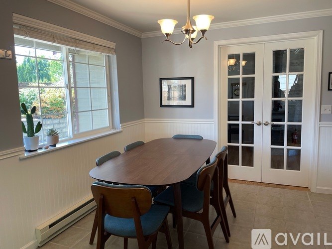 A dining room with a wooden table and chairs.