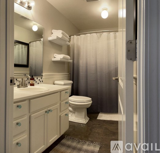 A bathroom with a white sink and toilet.
