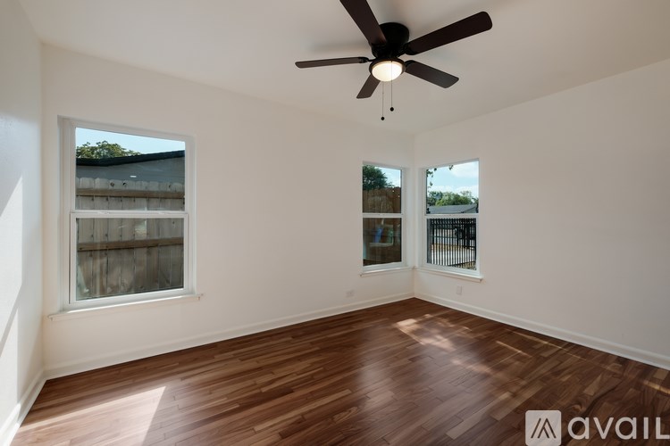 A room with wooden floors and a ceiling fan.