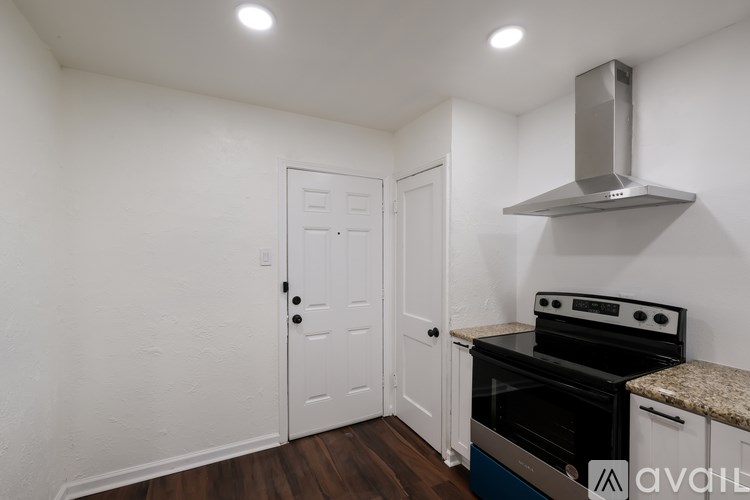 A kitchen with a stove top oven and a door.