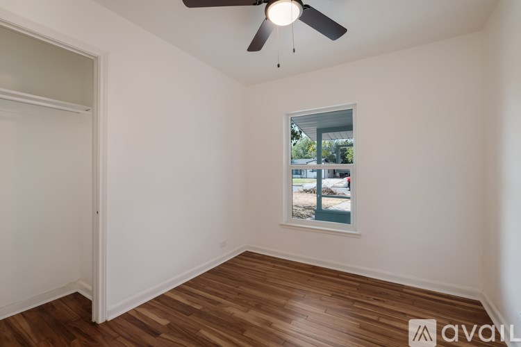A room with a ceiling fan and a window showing an outdoor view.