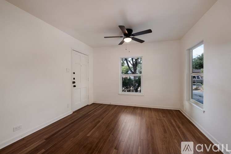 A room with wooden floors and a ceiling fan.