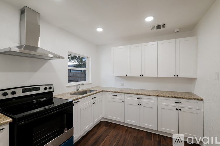 A kitchen with white cabinets and a black stove top oven.