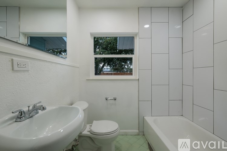 A white bathroom with a sink, toilet, and bathtub.