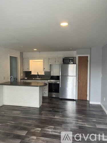 A kitchen with a white counter and a refrigerator.
