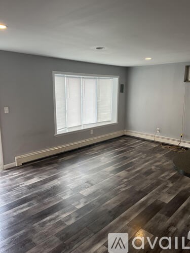 A room with grey walls and a window with white blinds.