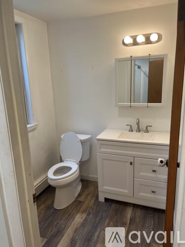 A white toilet and sink in a small bathroom.