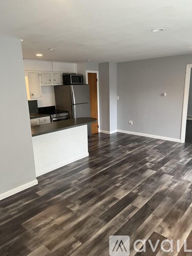 A kitchen with a refrigerator, microwave, and oven.