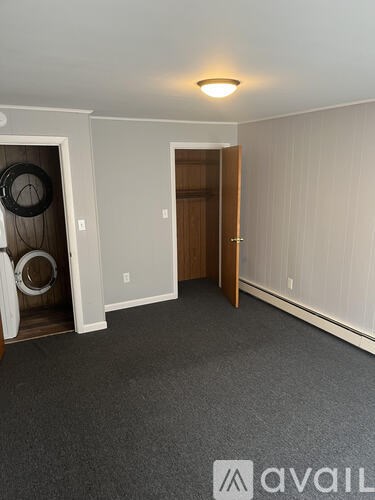 A room with a door and a wall-mounted speaker.