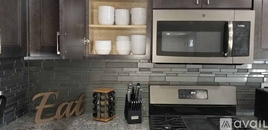 A kitchen with a stove top oven and a microwave above it.