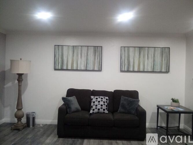 A living room with a couch, lamp, and two pictures on the wall.